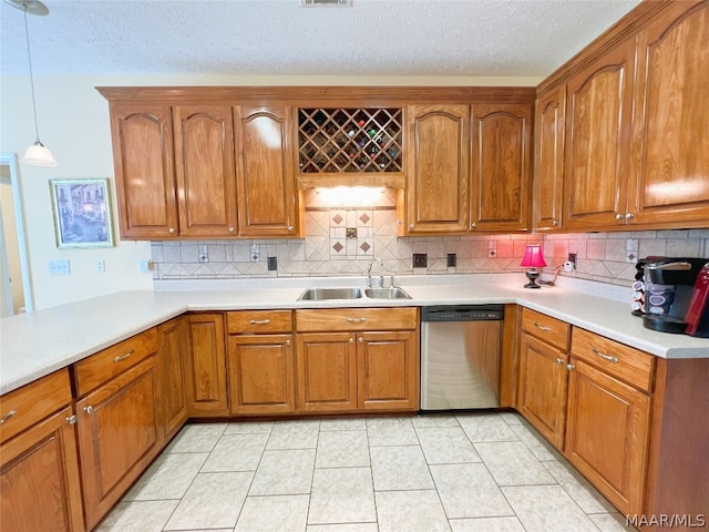 kitchen with light tile patterned flooring, pendant lighting, sink, stainless steel dishwasher, and kitchen peninsula