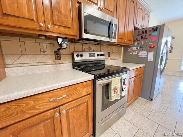 kitchen featuring tasteful backsplash, light tile patterned flooring, and appliances with stainless steel finishes