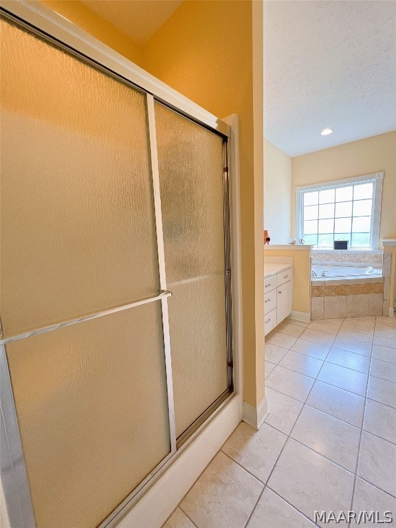 bathroom featuring vanity, shower with separate bathtub, tile patterned flooring, and a textured ceiling