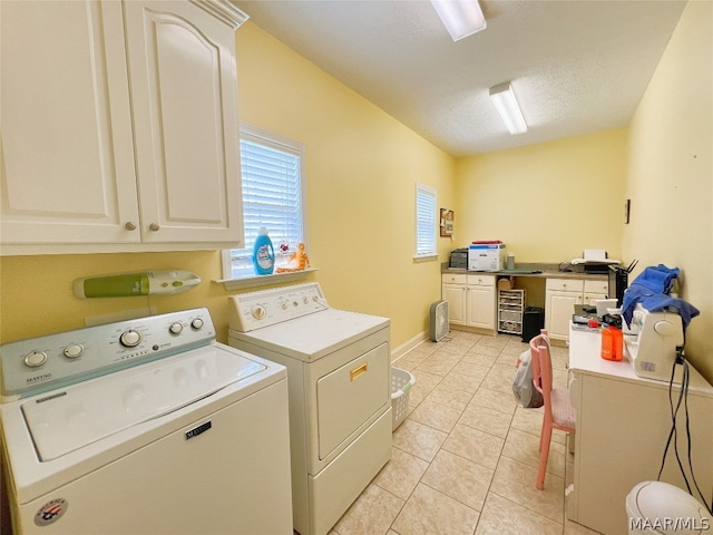 clothes washing area featuring cabinets, light tile patterned floors, independent washer and dryer, and a textured ceiling