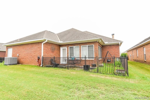 back of house featuring a yard and central AC unit