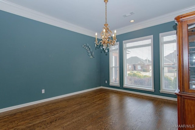 spare room with crown molding, dark wood-type flooring, and a notable chandelier