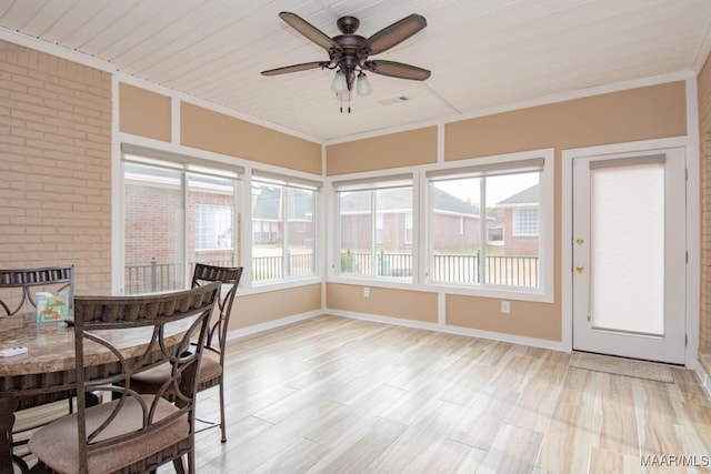 unfurnished sunroom featuring ceiling fan