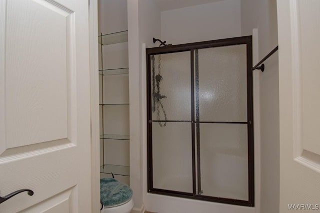 bathroom with an enclosed shower and toilet