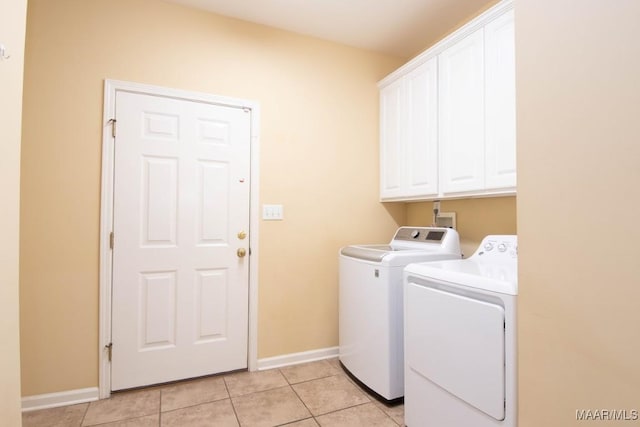 laundry area featuring cabinets, independent washer and dryer, and light tile patterned flooring