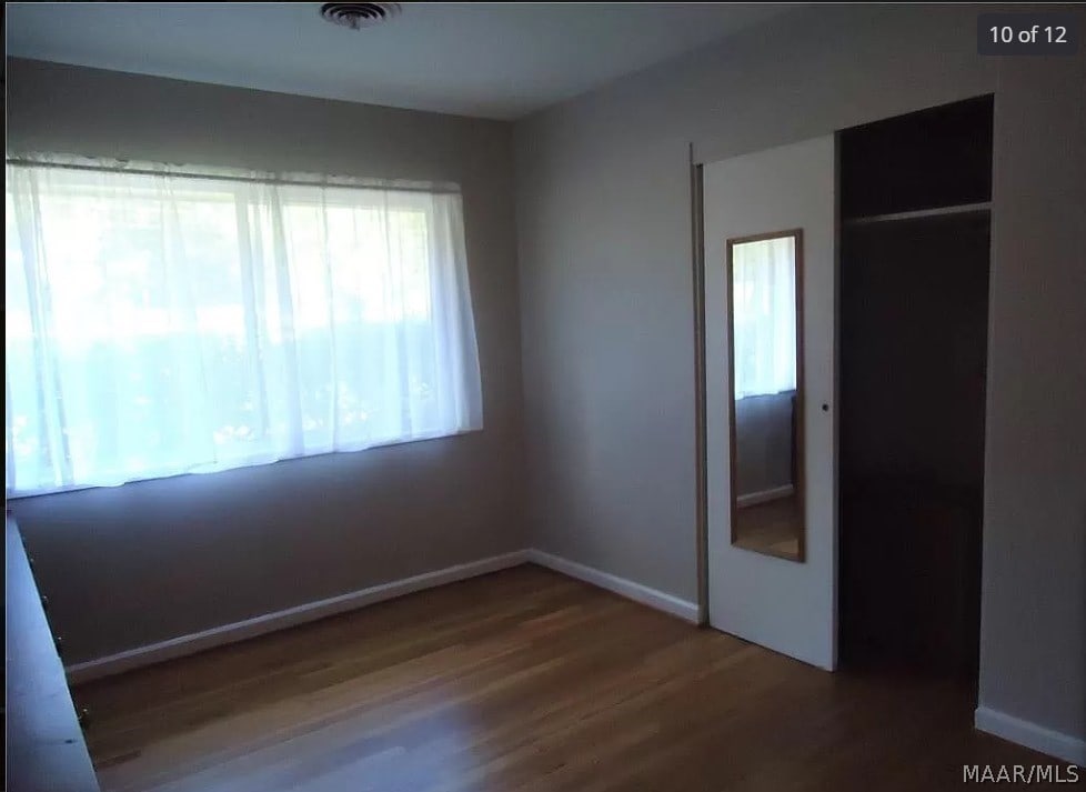 unfurnished bedroom featuring wood-type flooring and a closet