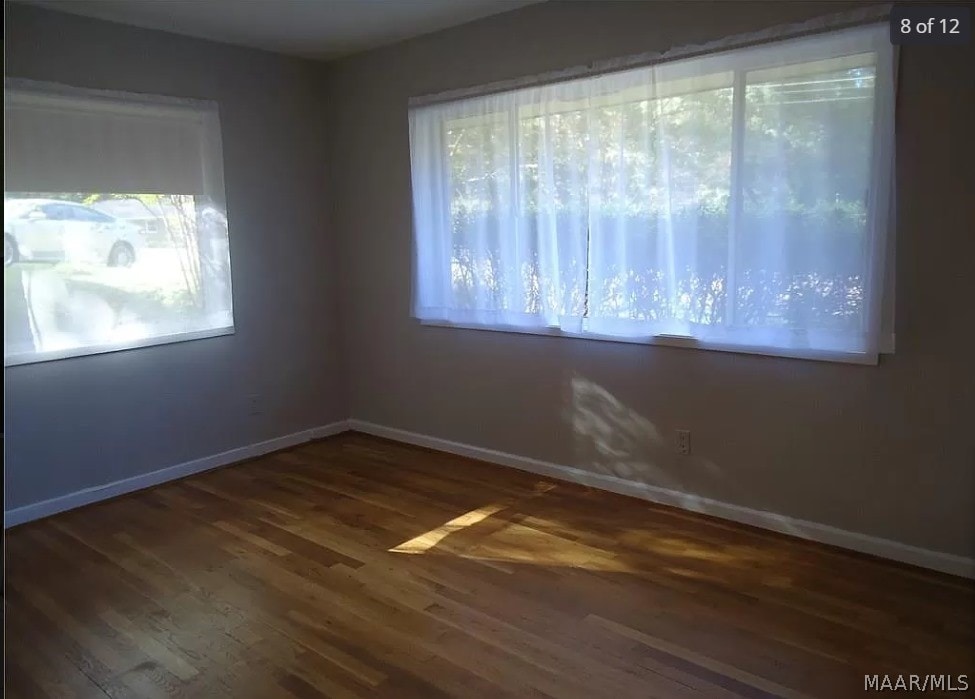 spare room with hardwood / wood-style flooring and a healthy amount of sunlight