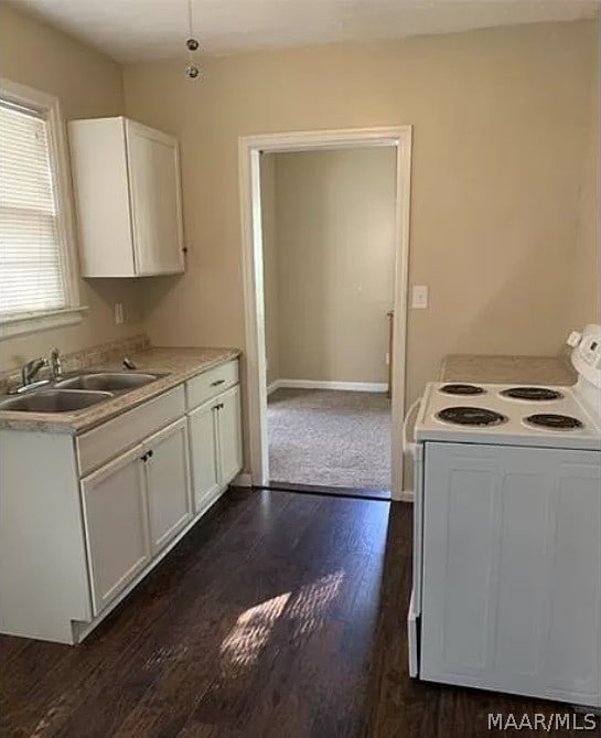 kitchen with sink, dark hardwood / wood-style flooring, electric range, and white cabinets