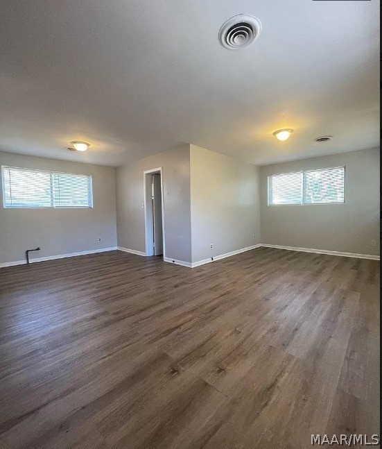 spare room with dark wood-style floors and baseboards
