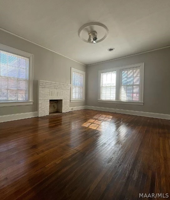 unfurnished living room featuring hardwood / wood-style flooring, crown molding, baseboards, and a fireplace