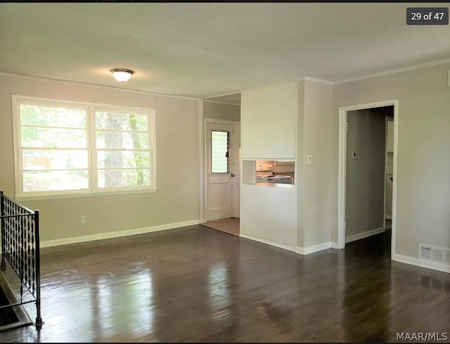 unfurnished living room featuring ornamental molding and dark hardwood / wood-style floors