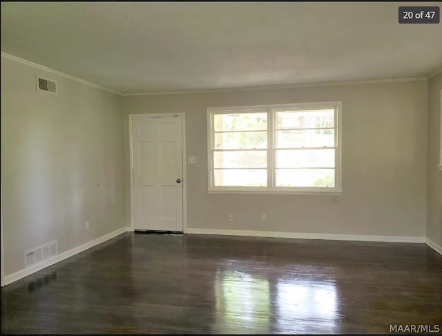 empty room with crown molding and dark hardwood / wood-style flooring