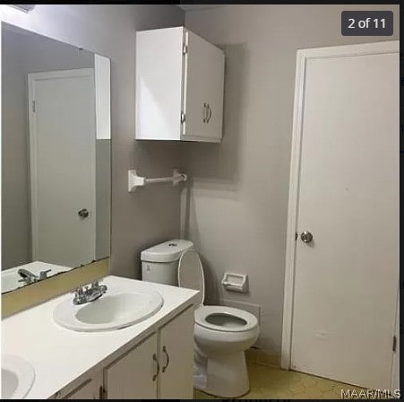 bathroom with dual vanity, tile patterned floors, and toilet