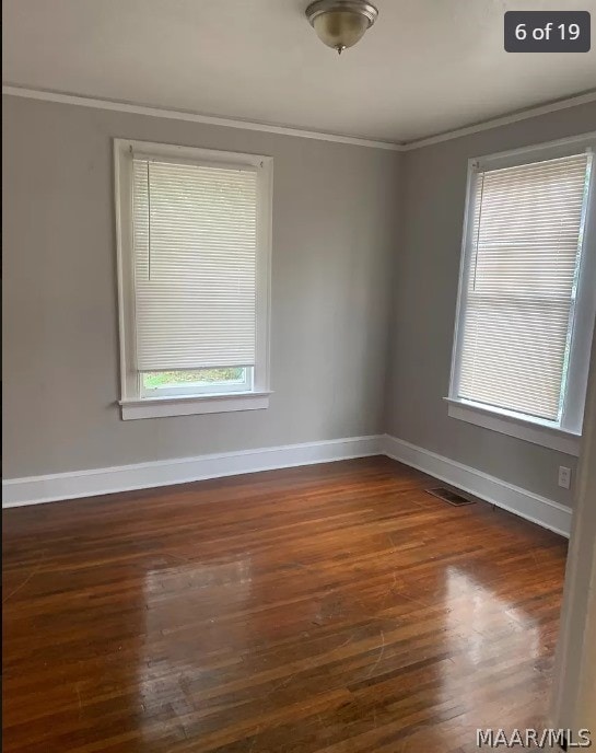 empty room featuring hardwood / wood-style flooring and ornamental molding