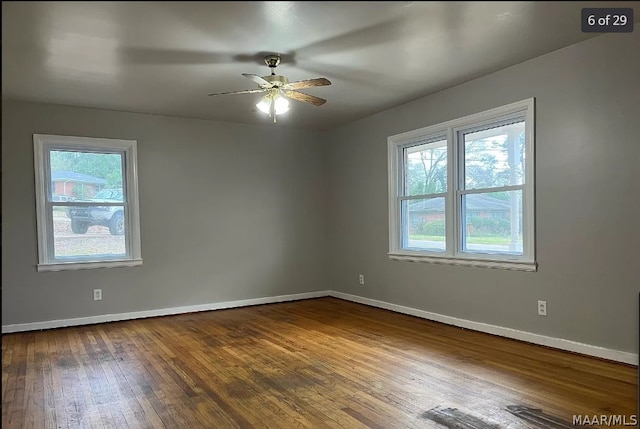 spare room with ceiling fan, hardwood / wood-style flooring, and a healthy amount of sunlight