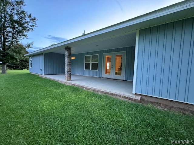 rear view of property with a patio, a yard, and french doors