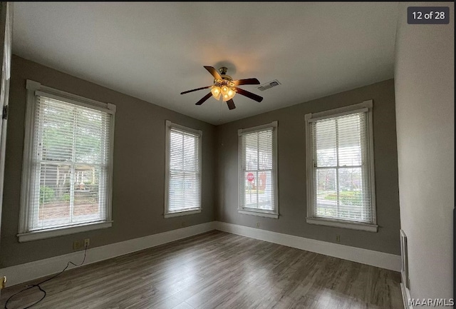 spare room featuring a healthy amount of sunlight and hardwood / wood-style flooring