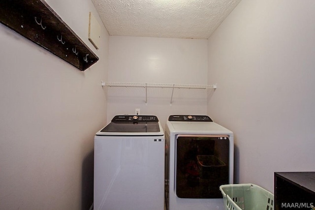 laundry area featuring a textured ceiling and washer and clothes dryer