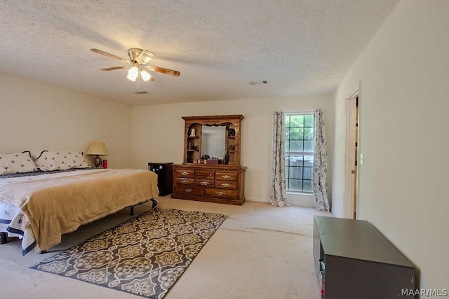 bedroom featuring light carpet, a textured ceiling, and ceiling fan