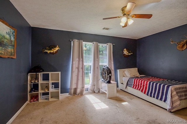 bedroom featuring carpet floors, a textured ceiling, and ceiling fan