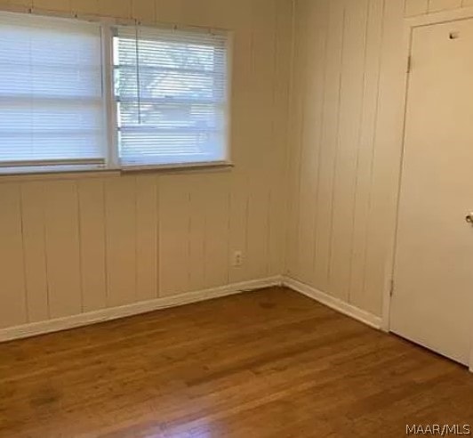 unfurnished room with wood-type flooring