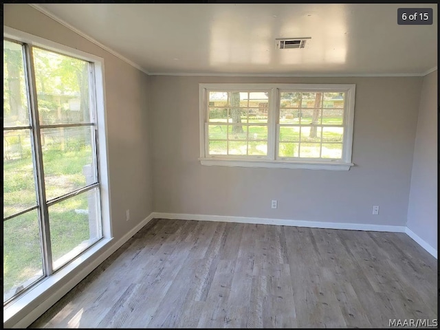 unfurnished room featuring hardwood / wood-style flooring and crown molding