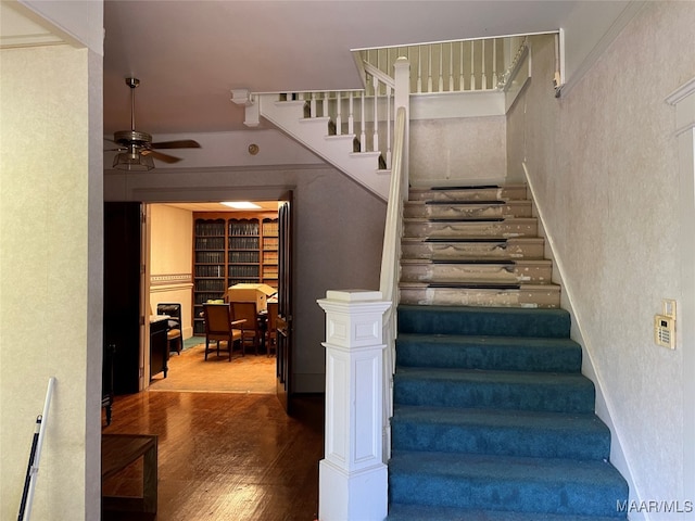 staircase featuring ceiling fan and wood-type flooring