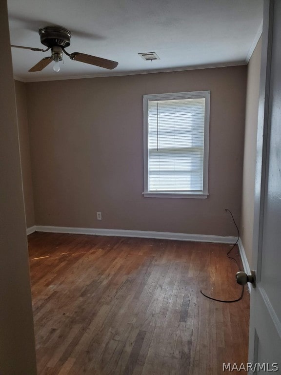 spare room featuring crown molding, ceiling fan, and wood-type flooring