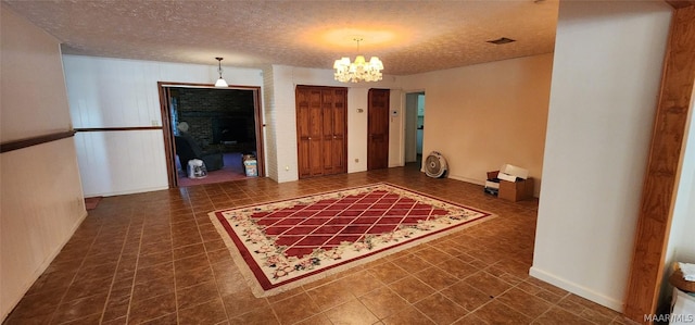 interior space featuring visible vents, a textured ceiling, and an inviting chandelier