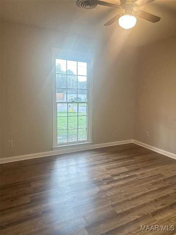 spare room with dark hardwood / wood-style flooring and ceiling fan