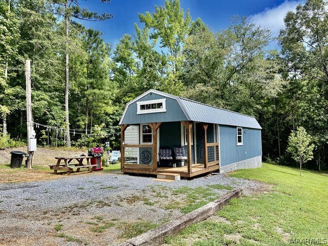 view of front of home with an outdoor structure and a front yard