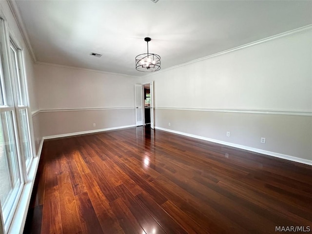 unfurnished room featuring crown molding, a wealth of natural light, dark hardwood / wood-style floors, and a chandelier