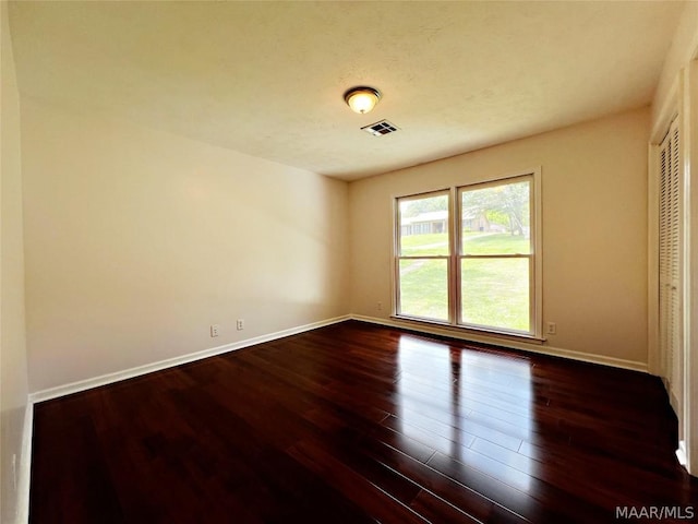 empty room with dark hardwood / wood-style floors