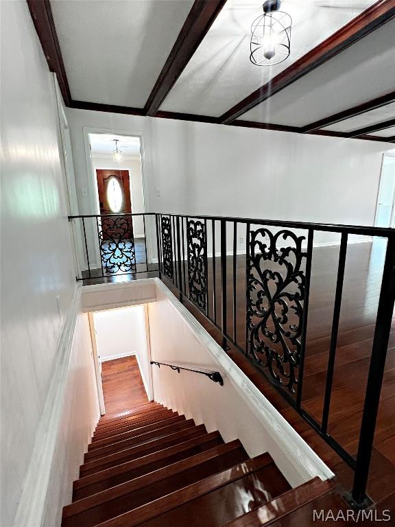 stairs featuring beam ceiling and wood-type flooring