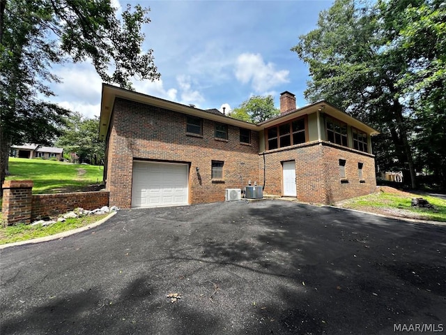 view of side of property with a garage and central AC unit