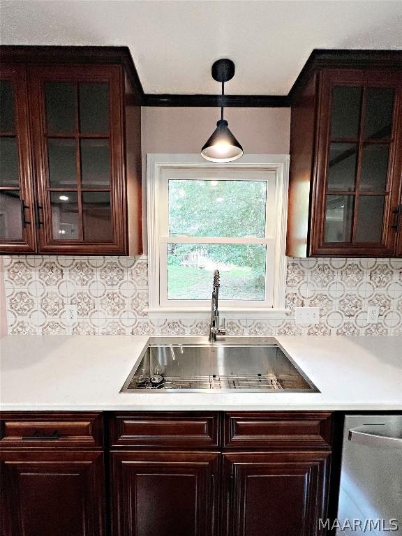 kitchen featuring sink, decorative backsplash, stainless steel dishwasher, and hanging light fixtures