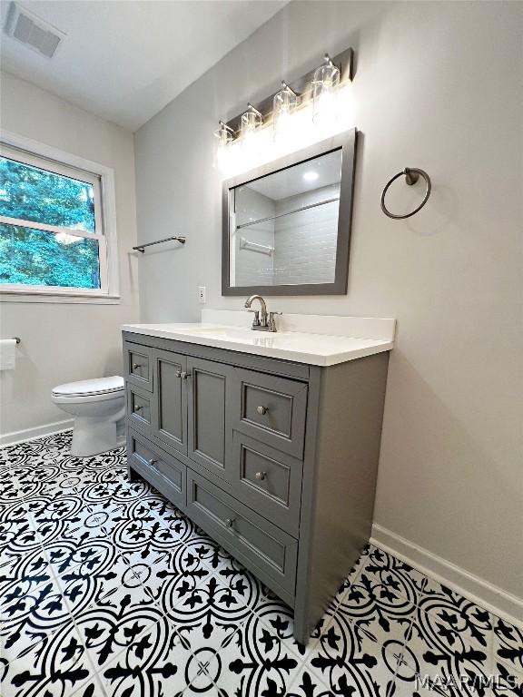 bathroom featuring vanity, tile patterned floors, and toilet