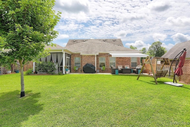 rear view of house with a yard and a sunroom