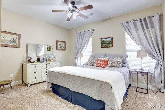 carpeted bedroom with multiple windows and ceiling fan