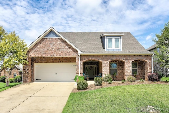 view of front of property with a garage, a front lawn, and covered porch