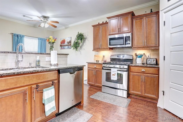 kitchen with stainless steel appliances, crown molding, sink, and dark wood-type flooring