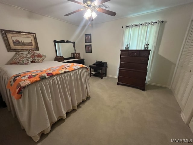 bedroom with a closet, ceiling fan, and light colored carpet