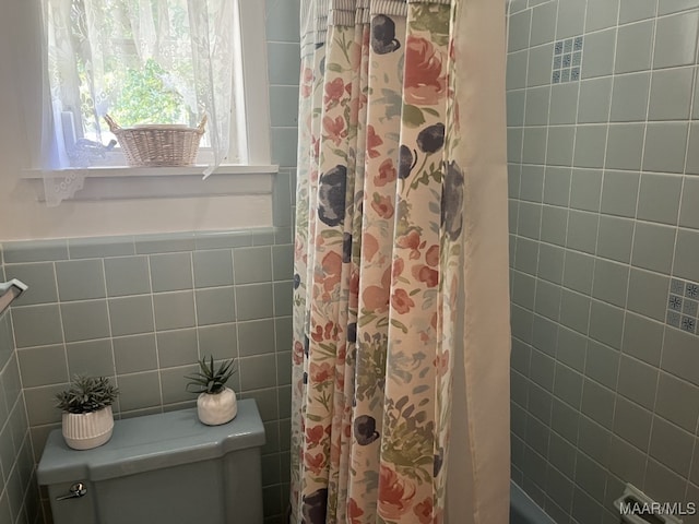 bathroom featuring tile walls and toilet