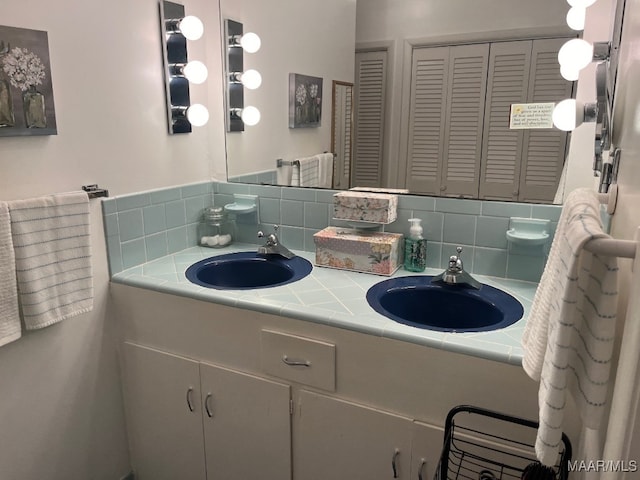 bathroom featuring backsplash and dual vanity