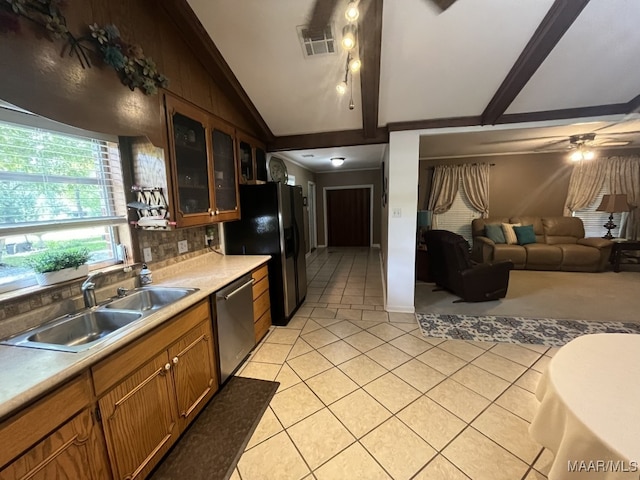 kitchen featuring vaulted ceiling with beams, tasteful backsplash, sink, dishwasher, and ceiling fan