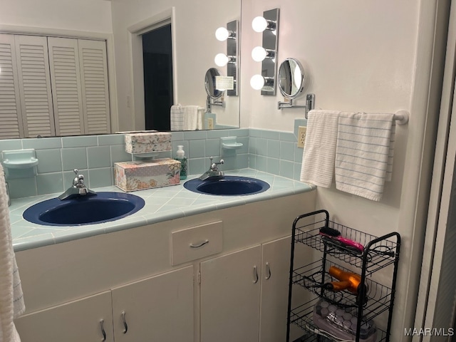 bathroom with dual vanity and tasteful backsplash