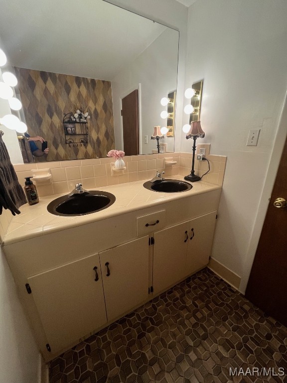 bathroom featuring tile patterned flooring, backsplash, and dual vanity