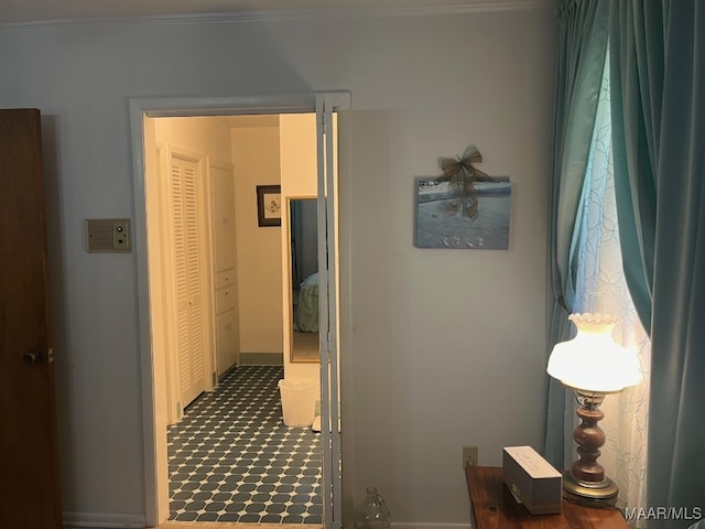 corridor with crown molding and tile patterned floors