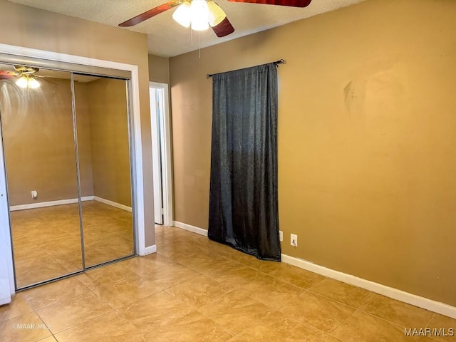 unfurnished bedroom with ceiling fan, a textured ceiling, and a closet