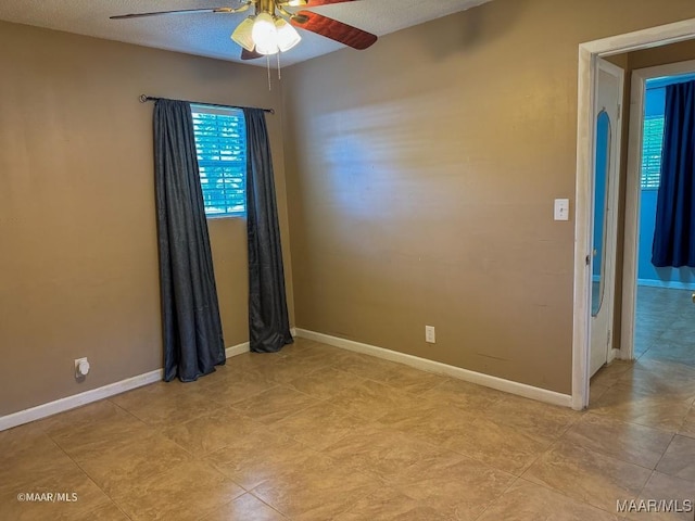 empty room featuring ceiling fan and a textured ceiling